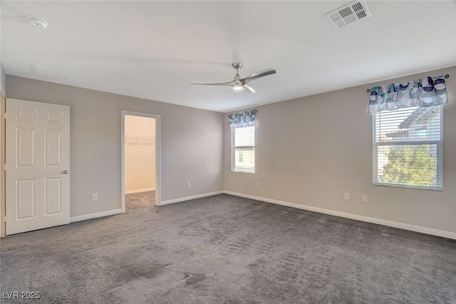 spare room with a wealth of natural light, carpet floors, and ceiling fan