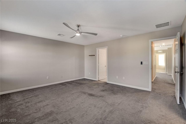 spare room featuring dark colored carpet and ceiling fan