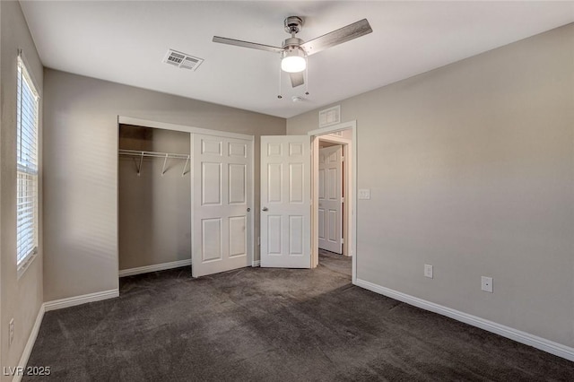 unfurnished bedroom featuring ceiling fan, a closet, and dark carpet