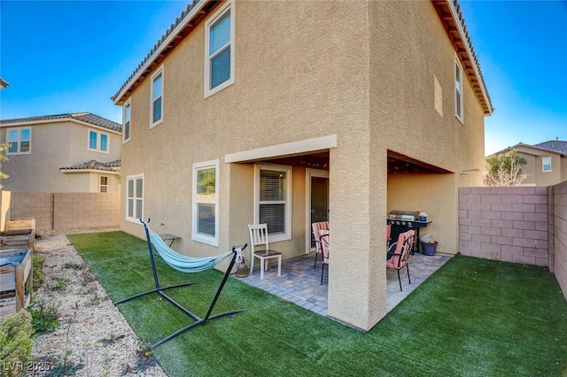 back of house with a yard and a patio