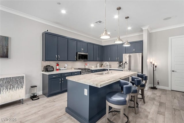 kitchen featuring pendant lighting, a kitchen island with sink, sink, a kitchen bar, and stainless steel appliances