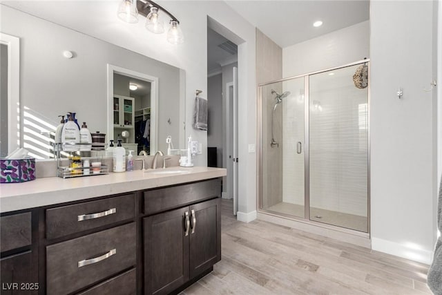 bathroom featuring vanity, hardwood / wood-style flooring, and a shower with shower door