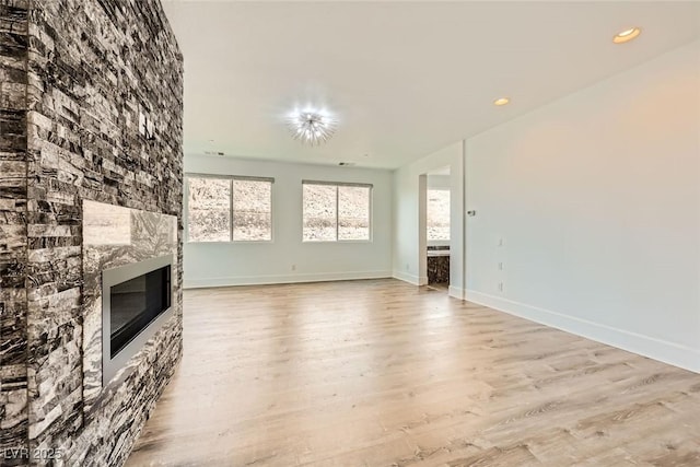 unfurnished living room featuring light hardwood / wood-style flooring and a fireplace