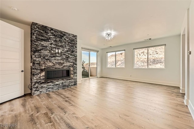 unfurnished living room with a fireplace and light hardwood / wood-style floors