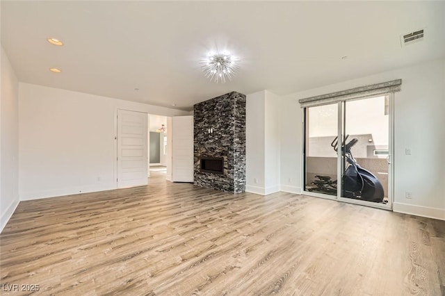 unfurnished living room featuring a fireplace and light hardwood / wood-style flooring