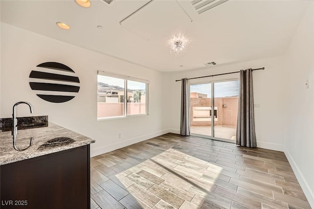 interior space with light stone counters and dark brown cabinets