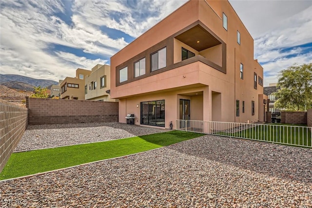 rear view of house featuring a yard, central AC unit, and a mountain view