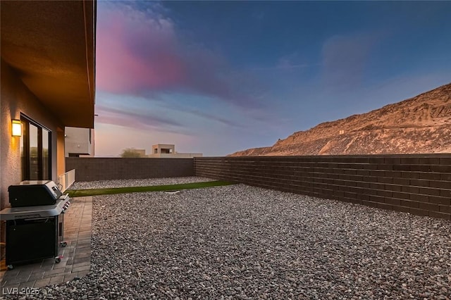 yard at dusk with a mountain view and a patio