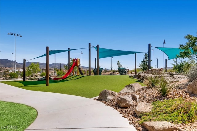 view of play area with a mountain view and a yard