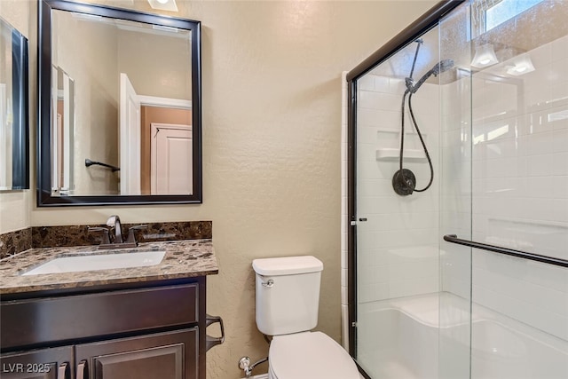 bathroom with vanity, toilet, and a shower with shower door