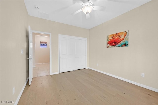 unfurnished bedroom featuring ceiling fan, a closet, and light hardwood / wood-style flooring