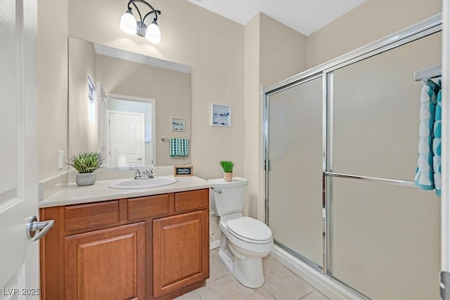 bathroom with tile patterned flooring, vanity, a shower with shower door, and toilet