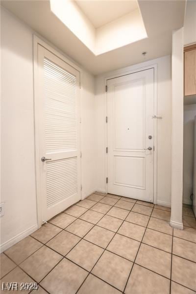 entryway featuring light tile patterned floors and a tray ceiling