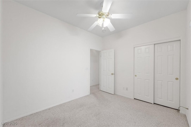 unfurnished bedroom with ceiling fan, light colored carpet, and a closet