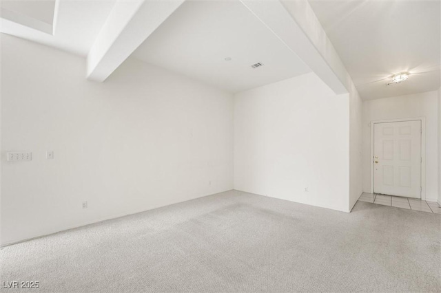 carpeted spare room featuring beam ceiling