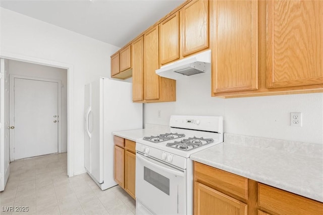 kitchen with light brown cabinets and white appliances