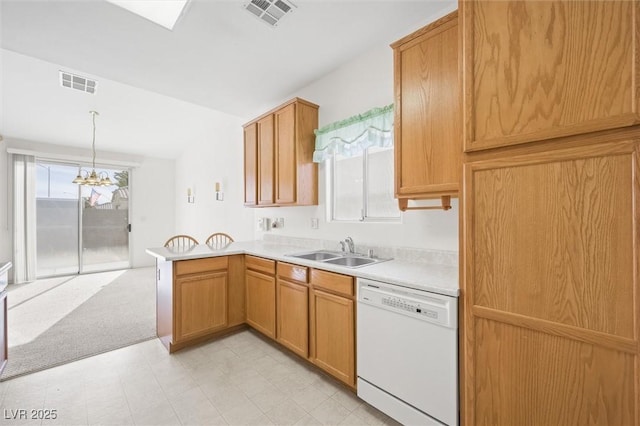 kitchen with kitchen peninsula, white dishwasher, sink, pendant lighting, and an inviting chandelier