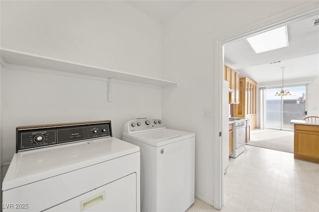 laundry area with a notable chandelier and washing machine and clothes dryer