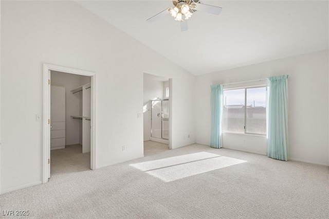 unfurnished bedroom featuring connected bathroom, light colored carpet, a spacious closet, and ceiling fan