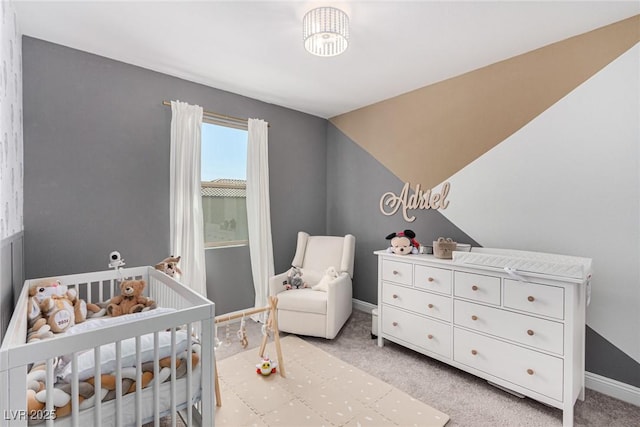 bedroom featuring lofted ceiling, light colored carpet, and a crib