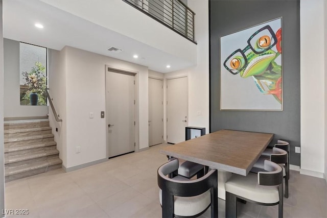 dining room with baseboards, visible vents, a high ceiling, stairs, and recessed lighting