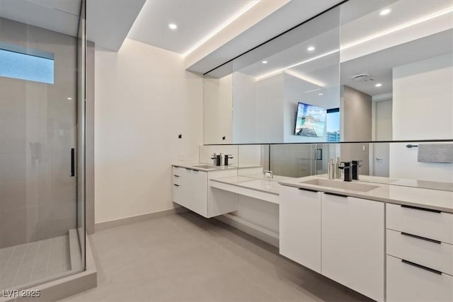 bathroom with a wealth of natural light, baseboards, a shower stall, and vanity