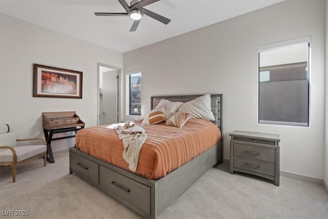 bedroom featuring a ceiling fan, light colored carpet, baseboards, and multiple windows