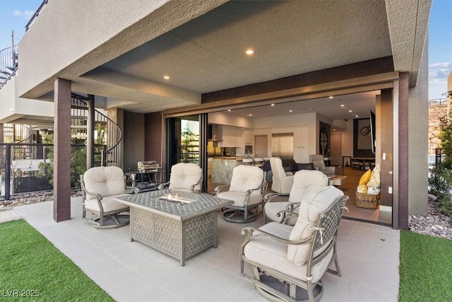 view of patio featuring an outdoor fire pit and stairway