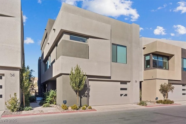 view of building exterior featuring concrete driveway and an attached garage