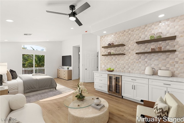 bedroom featuring ceiling fan, light wood-type flooring, and wine cooler