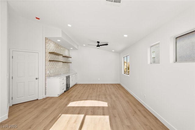 unfurnished living room with ceiling fan and light wood-type flooring