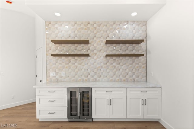 bar featuring white cabinets, light wood-type flooring, and beverage cooler