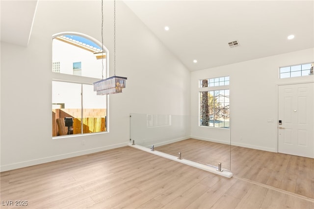 entrance foyer featuring light hardwood / wood-style flooring and high vaulted ceiling