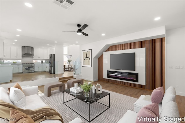 living room featuring light hardwood / wood-style flooring and ceiling fan