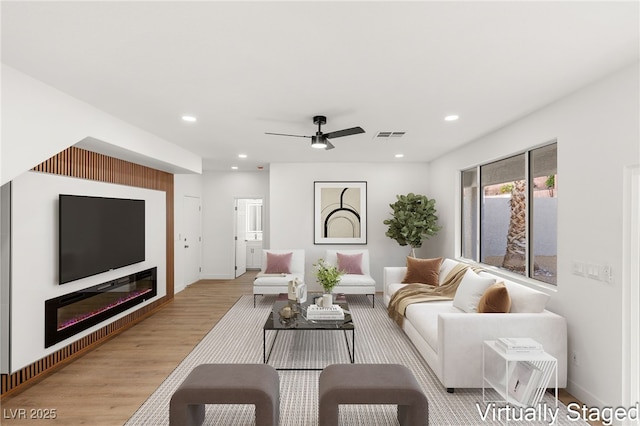 living room featuring ceiling fan and light hardwood / wood-style flooring