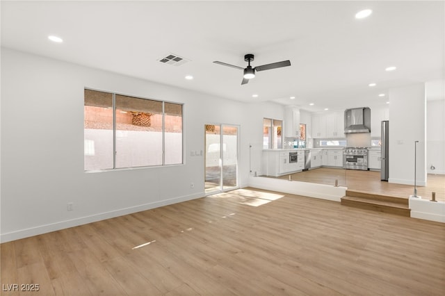 unfurnished living room featuring light hardwood / wood-style floors and ceiling fan