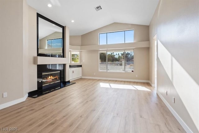 unfurnished living room featuring light wood-type flooring and vaulted ceiling