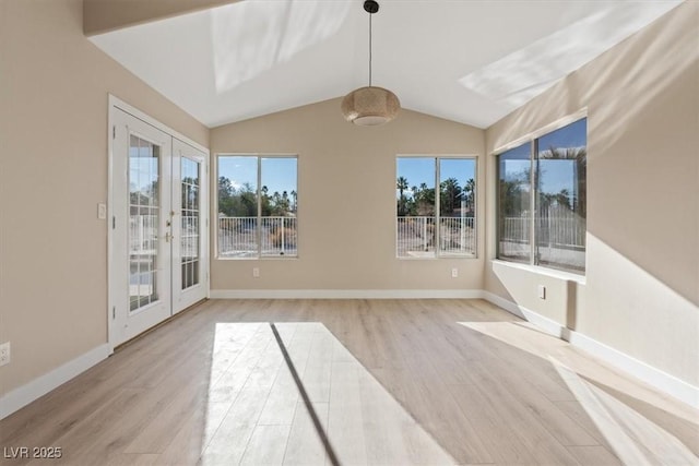 spare room with a wealth of natural light, french doors, and vaulted ceiling