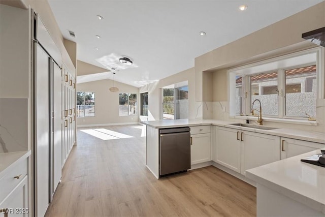 kitchen with white cabinets, sink, hanging light fixtures, light hardwood / wood-style flooring, and vaulted ceiling