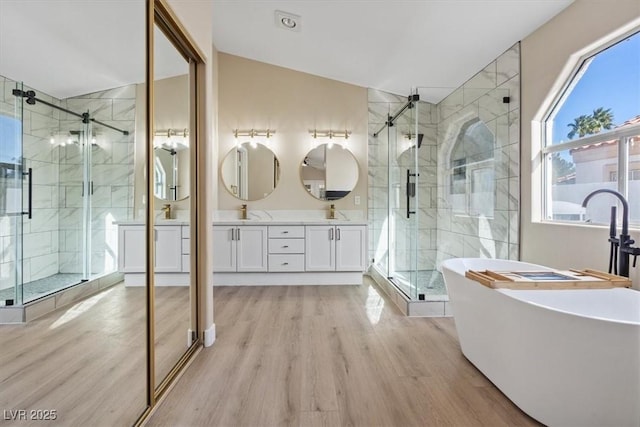 bathroom featuring hardwood / wood-style floors, vanity, and shower with separate bathtub