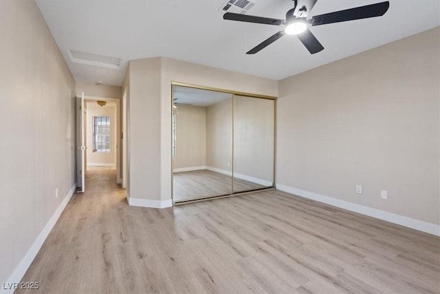 unfurnished bedroom featuring light hardwood / wood-style floors, a closet, and ceiling fan