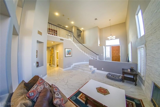 living room featuring a chandelier and a high ceiling