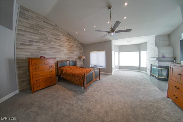 carpeted bedroom with vaulted ceiling, ceiling fan, and a multi sided fireplace