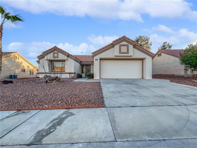 mediterranean / spanish-style home with central AC and a garage