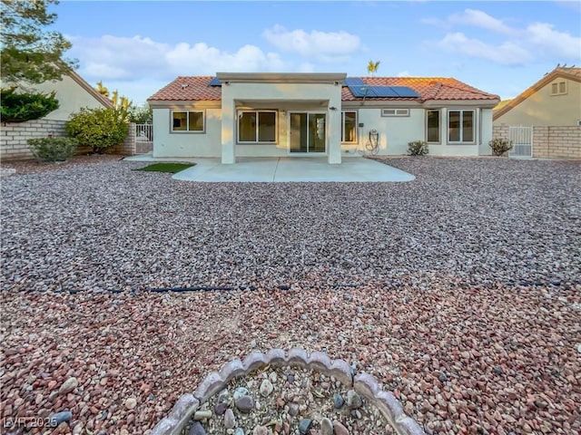 back of house featuring a patio and solar panels