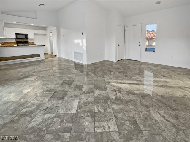 unfurnished living room with lofted ceiling