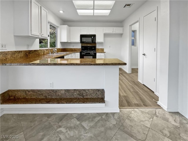 kitchen with kitchen peninsula, sink, white cabinets, and black appliances