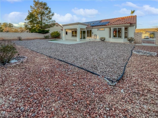 back of house featuring solar panels and a patio