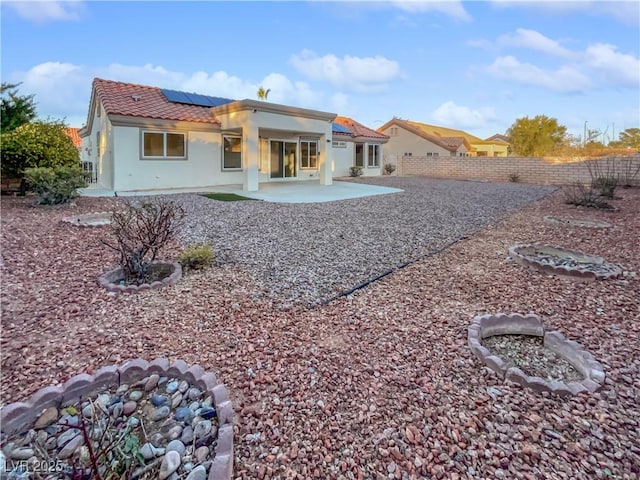 back of house with a patio area and solar panels