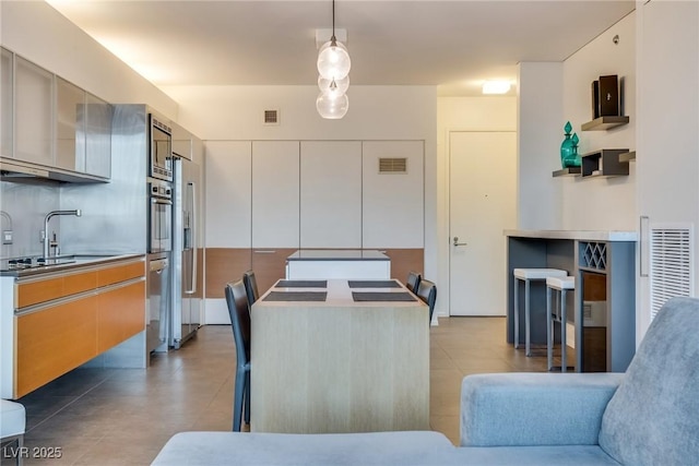 dining space featuring sink and light tile patterned floors